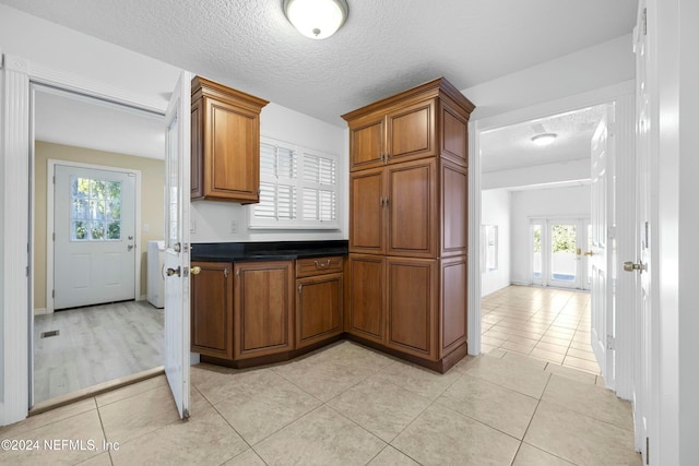 kitchen featuring a healthy amount of sunlight, light tile patterned floors, and a textured ceiling