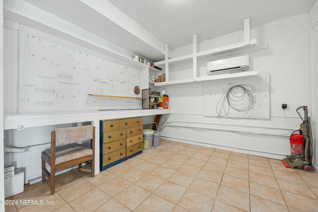 kitchen with a textured ceiling, a wall unit AC, and light tile patterned flooring