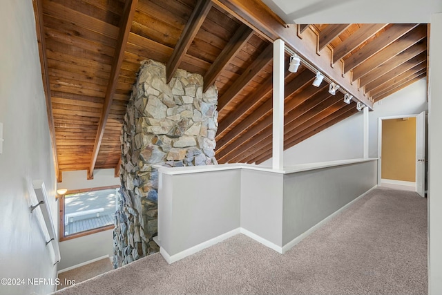 hall with carpet, lofted ceiling with beams, wood ceiling, and rail lighting