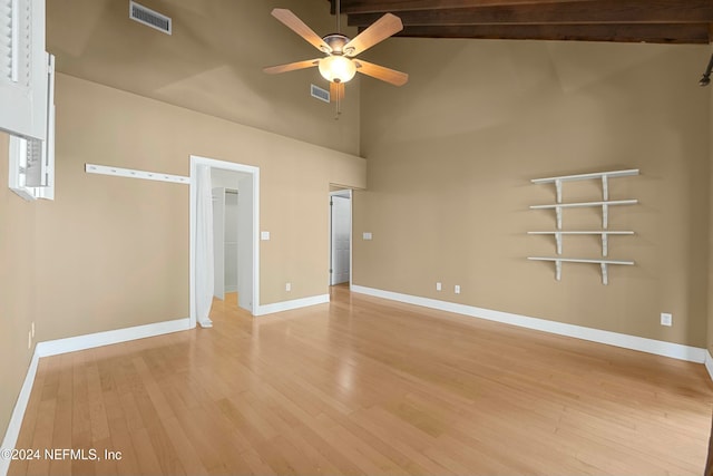 empty room with beamed ceiling, ceiling fan, light hardwood / wood-style floors, and high vaulted ceiling