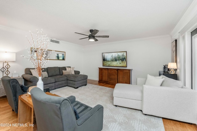 living room featuring ceiling fan, light hardwood / wood-style floors, and crown molding