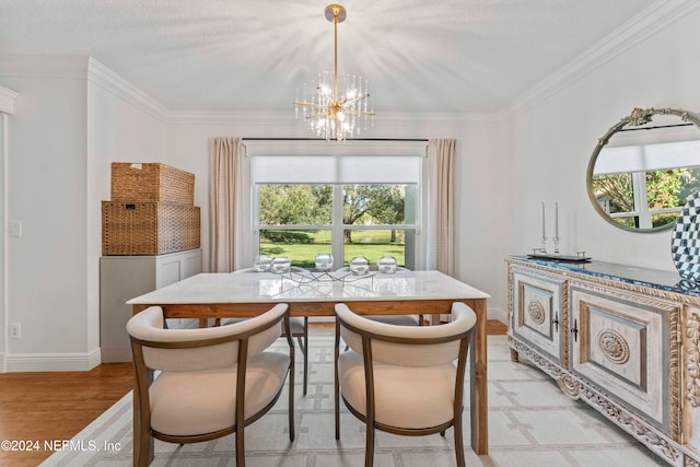 dining space with a textured ceiling, light hardwood / wood-style flooring, a notable chandelier, and crown molding