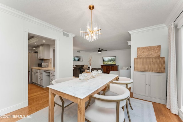 dining space with a textured ceiling, ceiling fan with notable chandelier, light hardwood / wood-style flooring, and ornamental molding