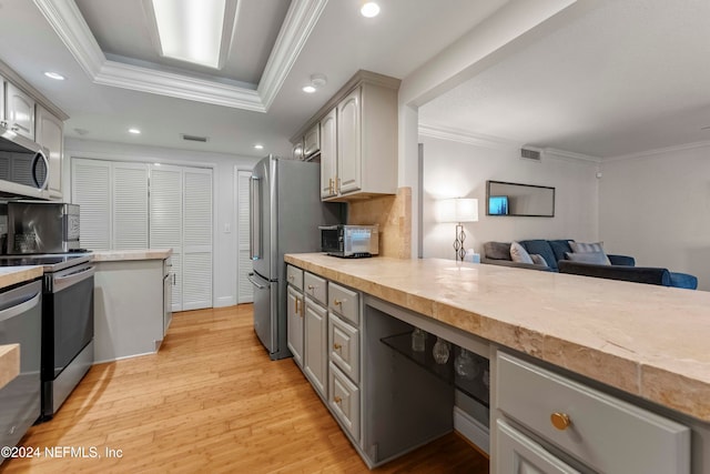 kitchen featuring gray cabinetry, ornamental molding, and stainless steel appliances