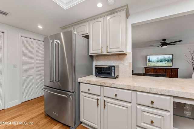 kitchen featuring ceiling fan, light hardwood / wood-style floors, ornamental molding, high end fridge, and white cabinetry