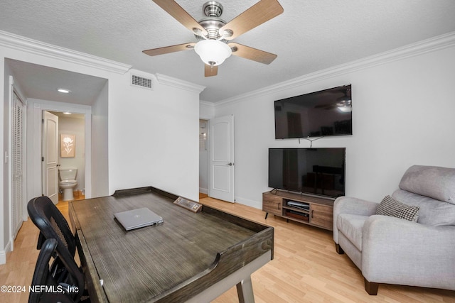 living room featuring crown molding, ceiling fan, light hardwood / wood-style floors, and a textured ceiling