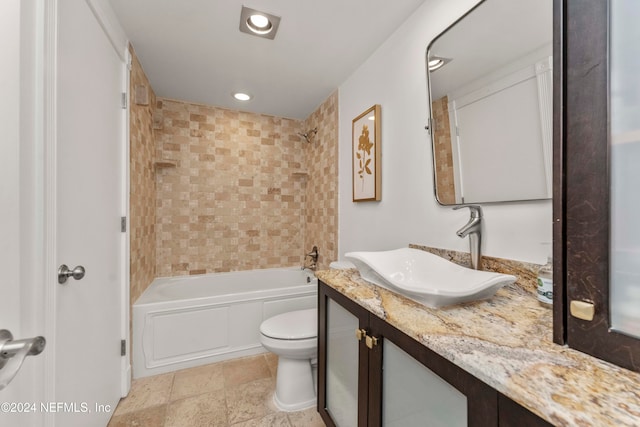 full bathroom featuring vanity, tiled shower / bath combo, and toilet