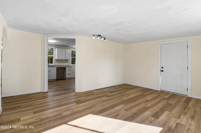 empty room with light hardwood / wood-style floors and a textured ceiling