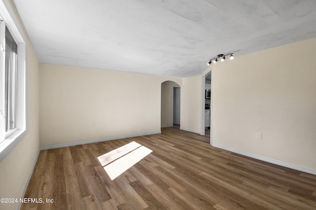 spare room with a textured ceiling and dark wood-type flooring