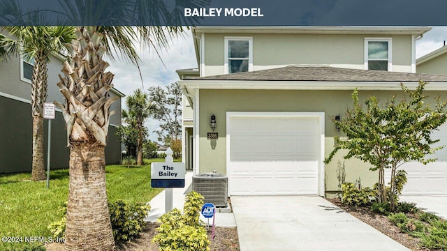 view of front of house featuring central air condition unit, a front yard, and a garage