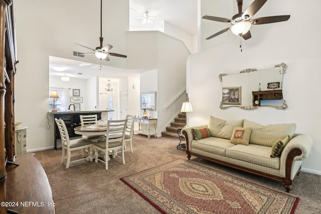 living room featuring carpet flooring and a towering ceiling