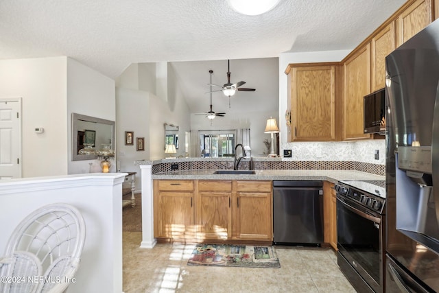 kitchen with kitchen peninsula, appliances with stainless steel finishes, a textured ceiling, sink, and light tile patterned flooring