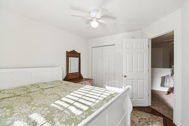 bedroom featuring a textured ceiling, dark hardwood / wood-style flooring, a closet, and ceiling fan