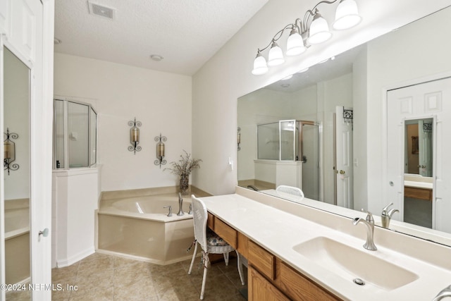 bathroom with a textured ceiling, vanity, tile patterned floors, and independent shower and bath