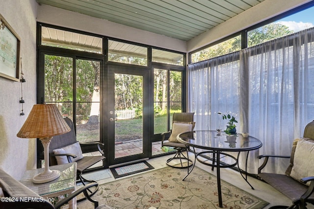 sunroom featuring wooden ceiling and a healthy amount of sunlight