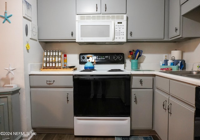 kitchen featuring white appliances and dark hardwood / wood-style floors