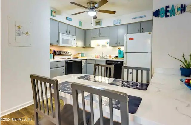 kitchen with ceiling fan, sink, dark wood-type flooring, kitchen peninsula, and white appliances