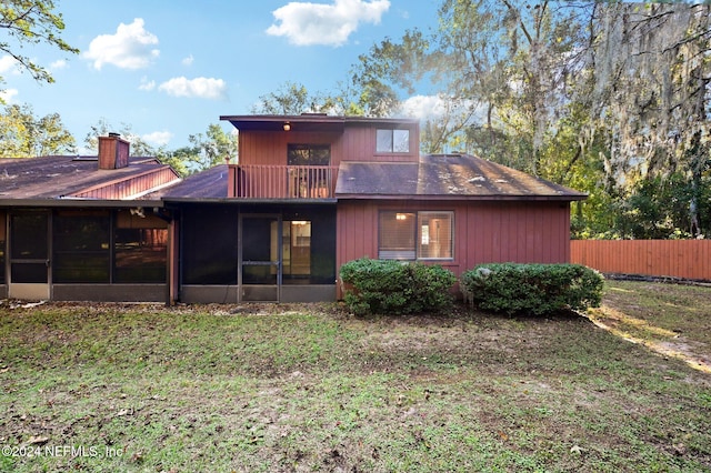 back of property featuring a sunroom and a balcony