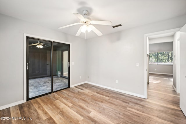 empty room with ceiling fan and light hardwood / wood-style flooring