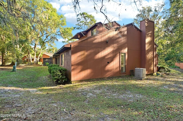 view of side of property featuring a yard and central AC unit