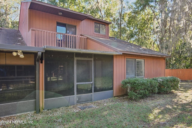 rear view of house featuring a balcony and a sunroom