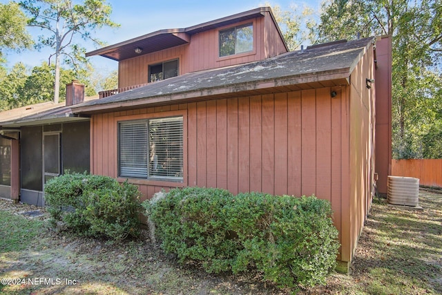 view of side of property featuring cooling unit and a sunroom