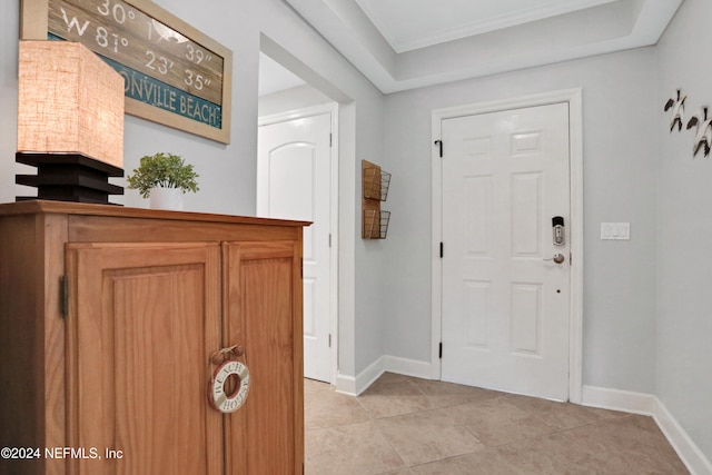 tiled foyer featuring crown molding