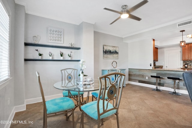 dining space with ceiling fan, light tile patterned floors, and ornamental molding