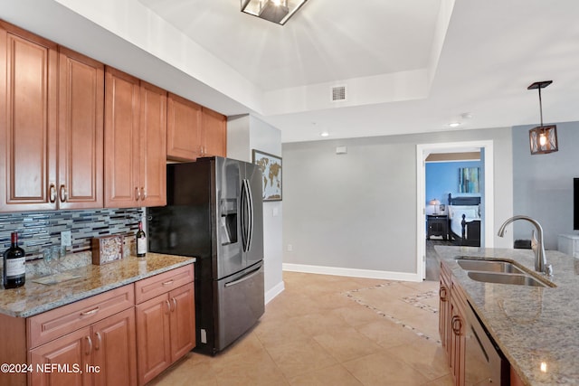 kitchen featuring sink, stainless steel appliances, light stone counters, backsplash, and decorative light fixtures