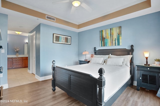 bedroom featuring connected bathroom, ceiling fan, crown molding, and light hardwood / wood-style floors