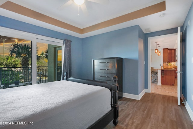 bedroom featuring access to outside, wood-type flooring, and ceiling fan with notable chandelier