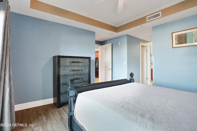 bedroom with crown molding, ceiling fan, and dark wood-type flooring