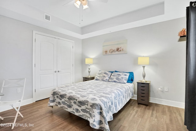 bedroom featuring ceiling fan, a closet, and hardwood / wood-style flooring