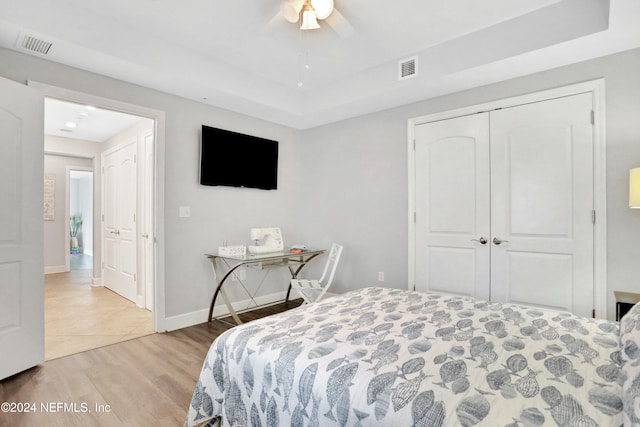 bedroom with ceiling fan, light wood-type flooring, and a closet