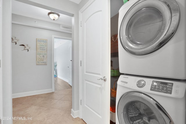 washroom with light tile patterned floors and stacked washing maching and dryer