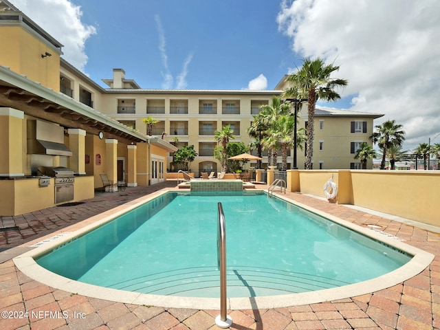 view of swimming pool featuring a patio and an outdoor kitchen