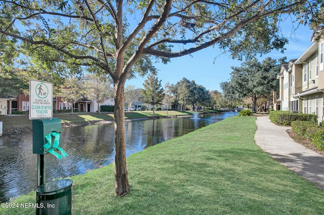 view of community with a lawn and a water view