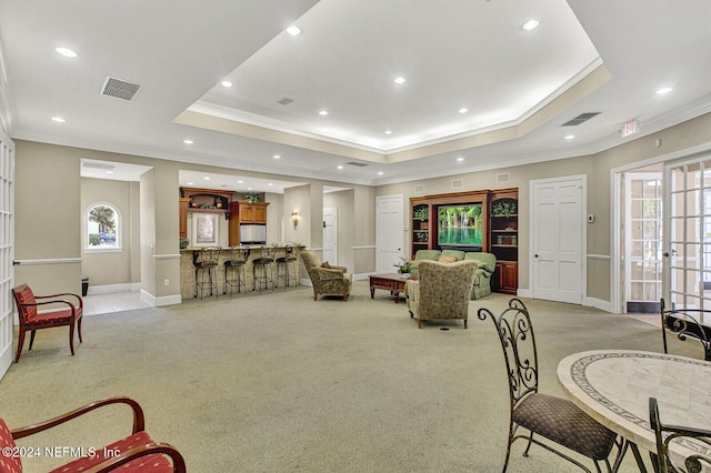 carpeted living room featuring french doors, a raised ceiling, plenty of natural light, and crown molding