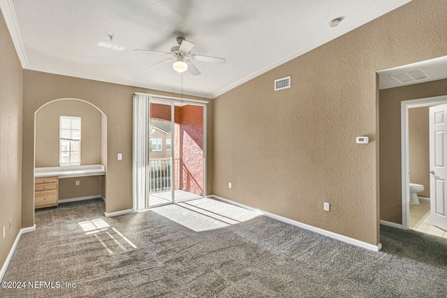 unfurnished bedroom featuring ceiling fan, built in desk, ornamental molding, and access to outside