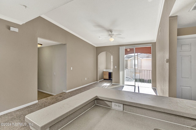 interior space featuring carpet flooring, vaulted ceiling, ceiling fan, and ornamental molding