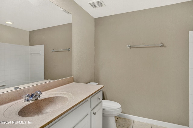 bathroom with tile patterned floors, vanity, toilet, and a shower