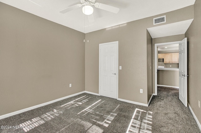 unfurnished bedroom with ceiling fan and dark colored carpet