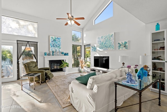 tiled living room with high vaulted ceiling, ceiling fan, and a high end fireplace