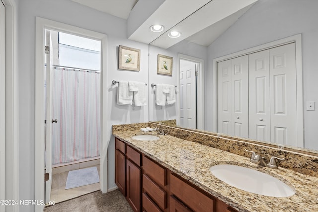 bathroom featuring a shower with shower curtain, vanity, and vaulted ceiling