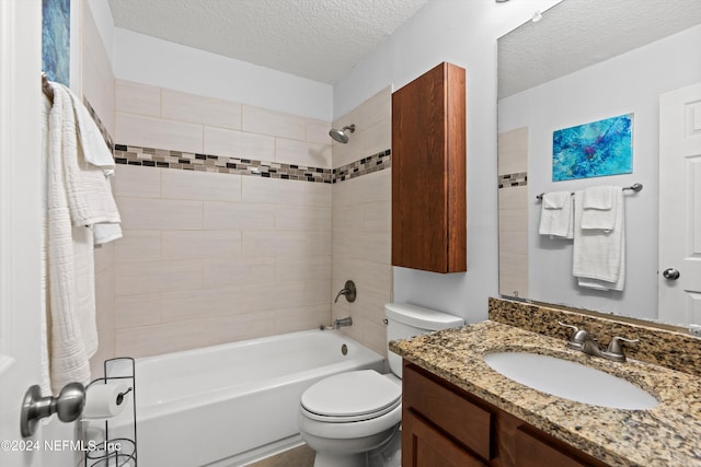 full bathroom featuring tiled shower / bath, vanity, a textured ceiling, and toilet