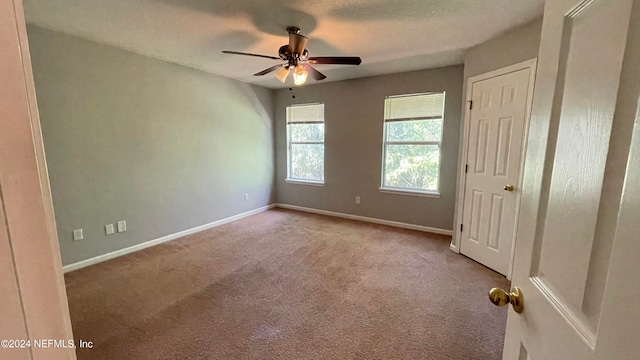 empty room with ceiling fan and light carpet