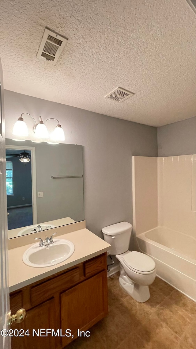 full bathroom with vanity, bathtub / shower combination, ceiling fan, toilet, and a textured ceiling