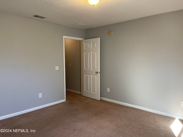 carpeted spare room with a textured ceiling