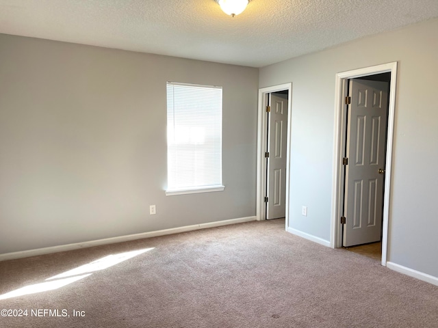 carpeted spare room with a textured ceiling