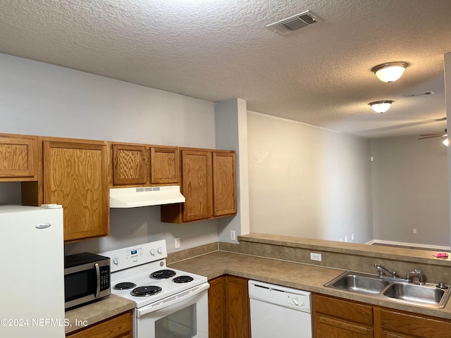 kitchen with a textured ceiling, ceiling fan, sink, and white appliances